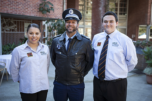 Photo of police officer and two students smiling