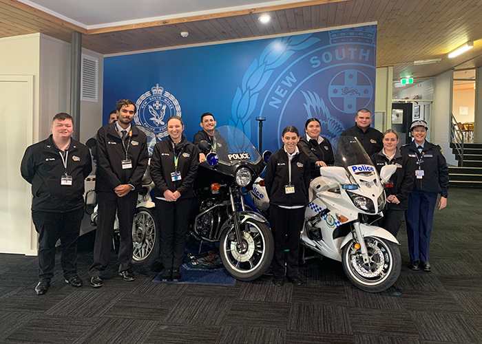 Photo of police employees standing with police motorcycles