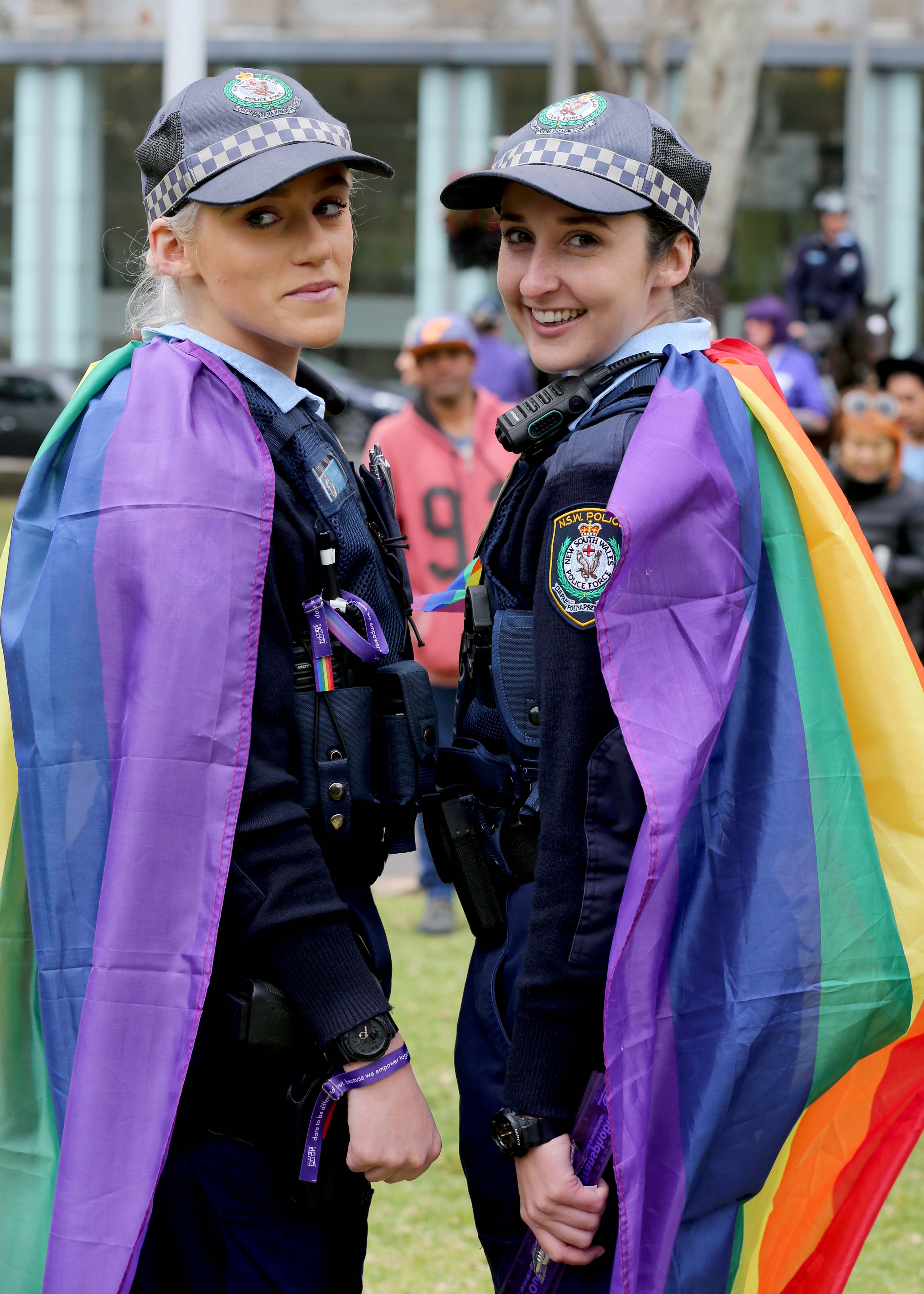 Two officers, both female, wearing rainbow flag